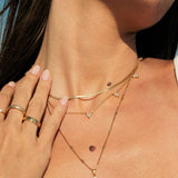 Close-up of a person wearing gold necklaces with gold necklaces