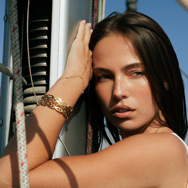 Woman in a white tank top on a boat with a blue sky background