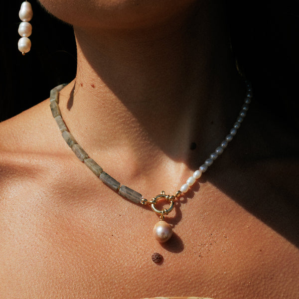 Close-up of a person wearing a pearl necklace 