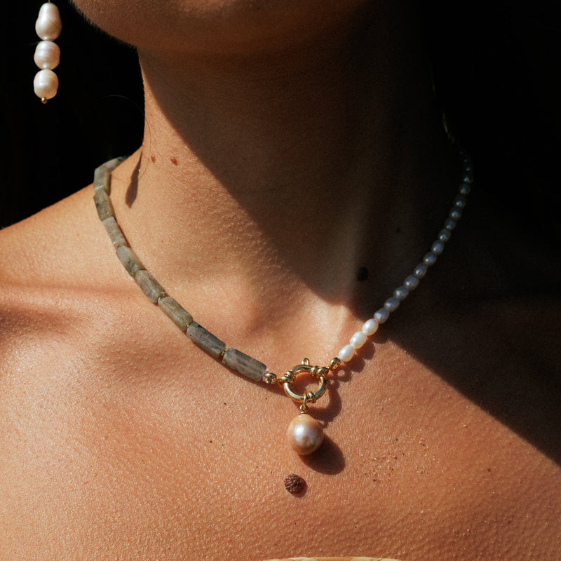 Close-up of a person wearing a pearl necklace 