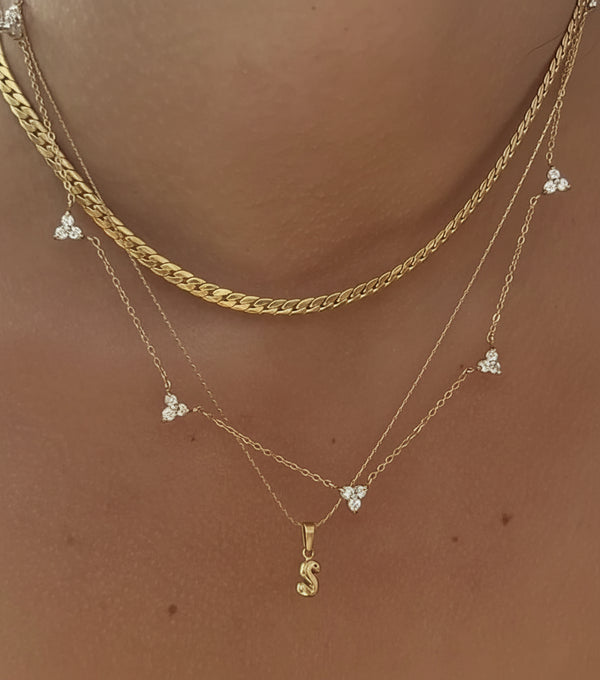 Gold necklaces with pendants on a skin background